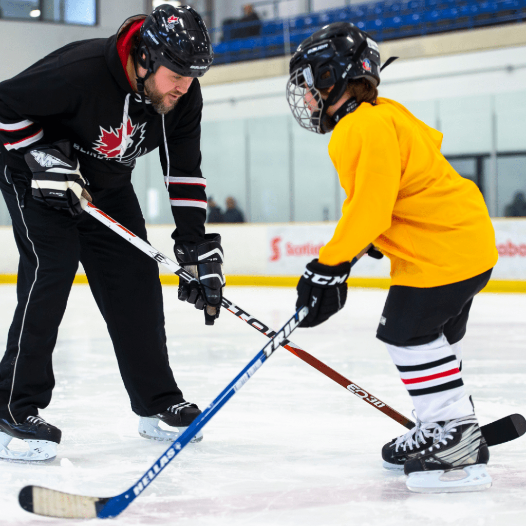 coach helping youth on the ice during practice