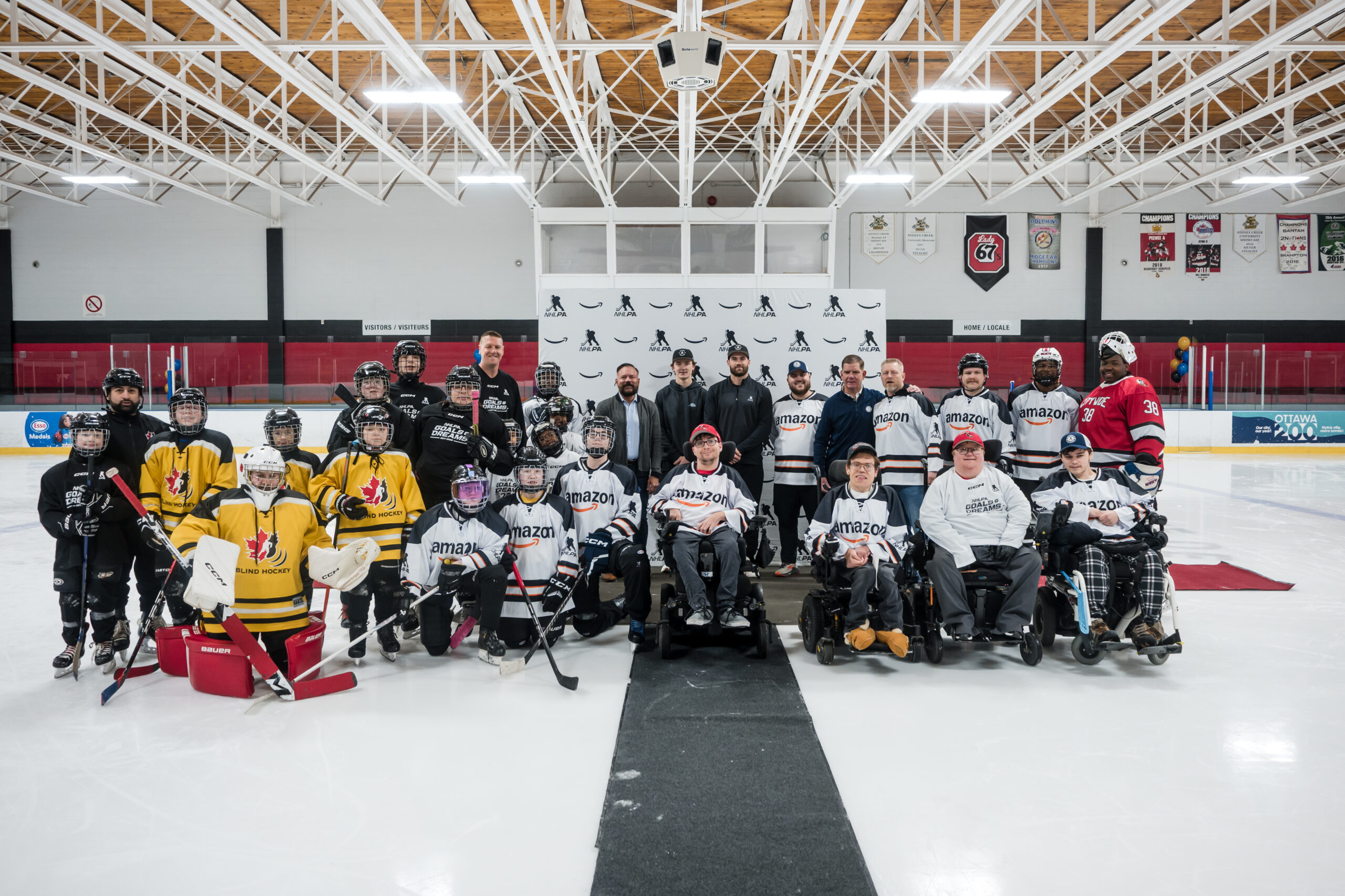 group photo on the ice infront of nhlpa media wall