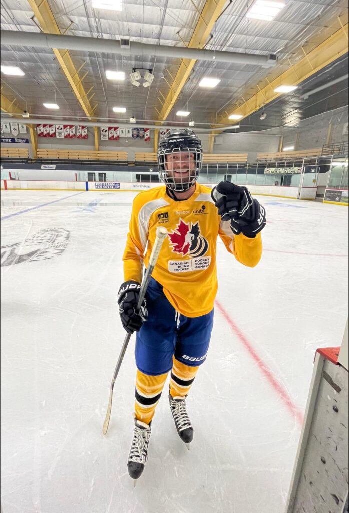 Dave smiles on the ice wearing a yellow jersey during the camp inside Iceland Arena